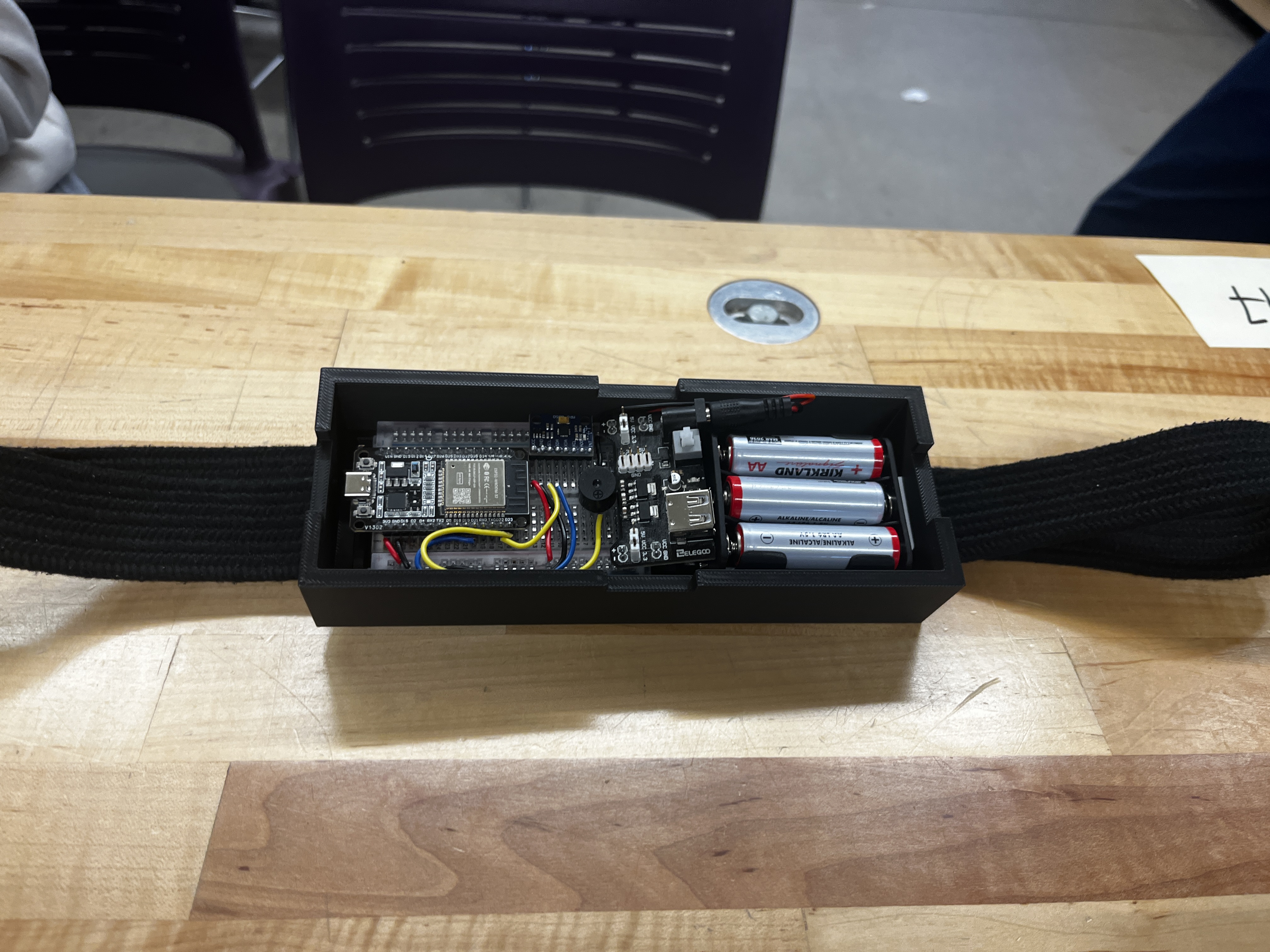 Wearable ESP32 motion detection device in a 3D-printed enclosure with battery pack on an elastic strap